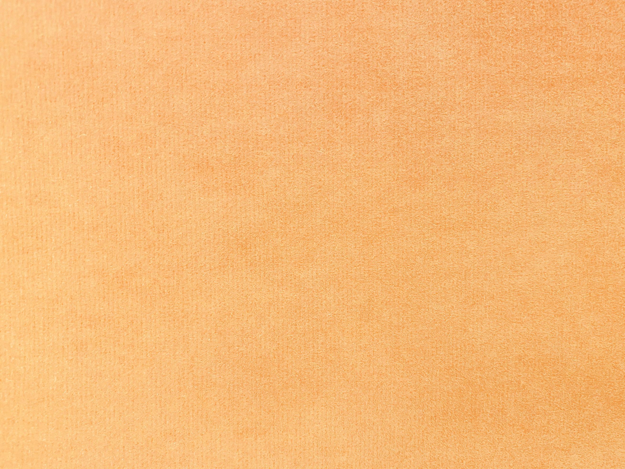 Orange velvet fabric texture used as background. Empty orange fabric