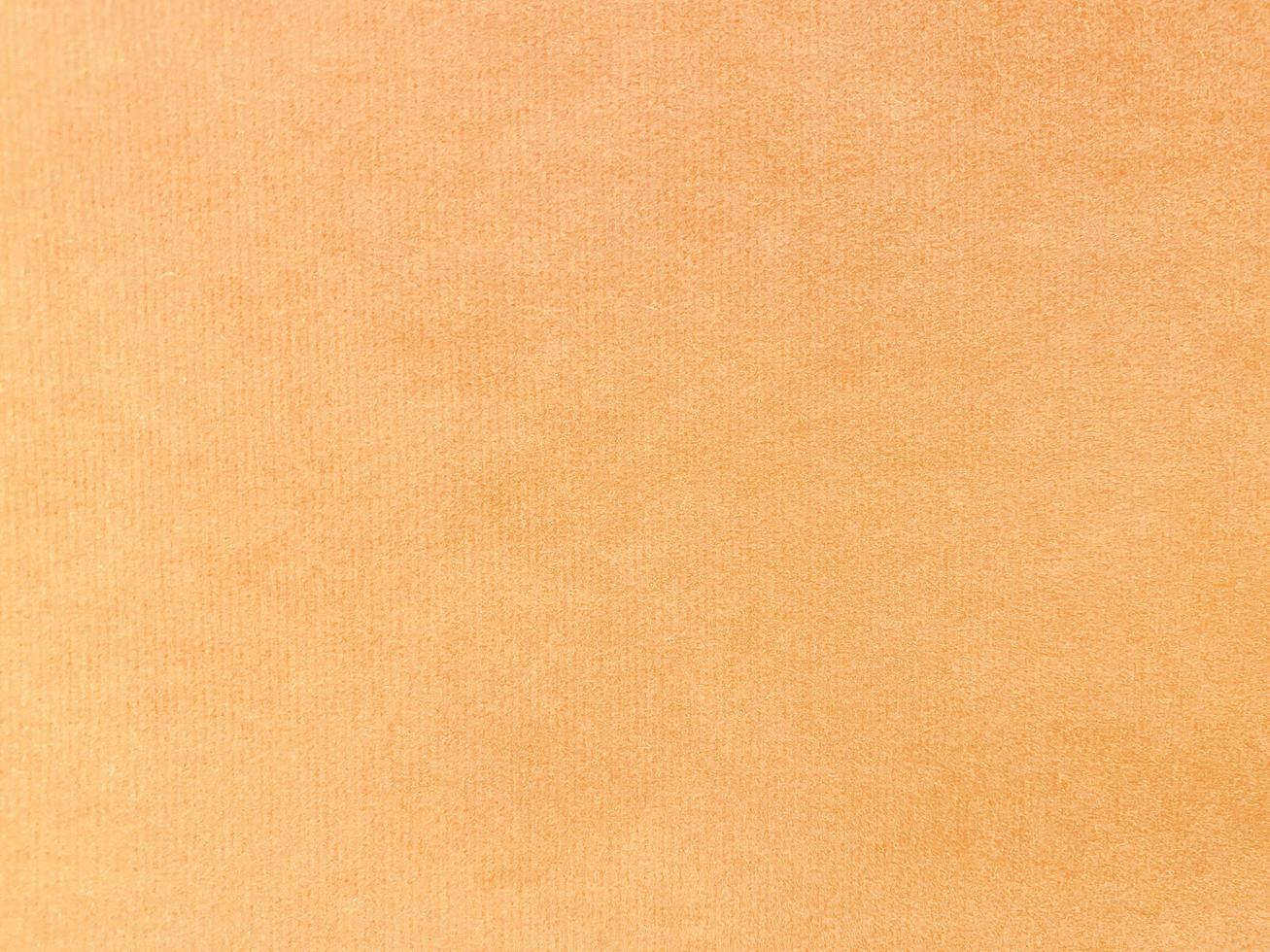 textura de tela de terciopelo naranja utilizada como fondo. fondo de tela naranja vacío de material textil suave y liso. hay espacio para el texto. foto