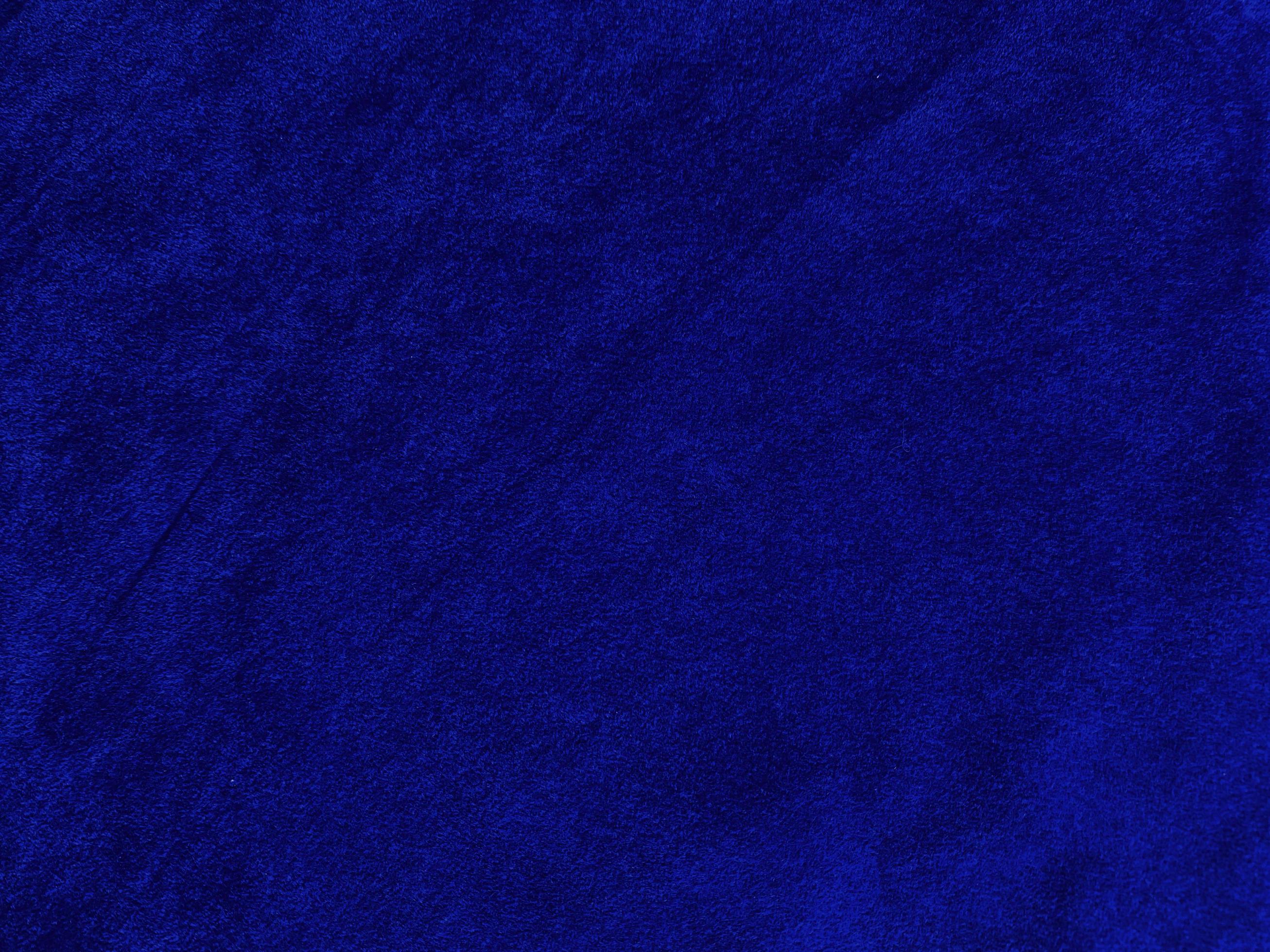 Blue velvet fabric texture used as background. Empty blue fabric