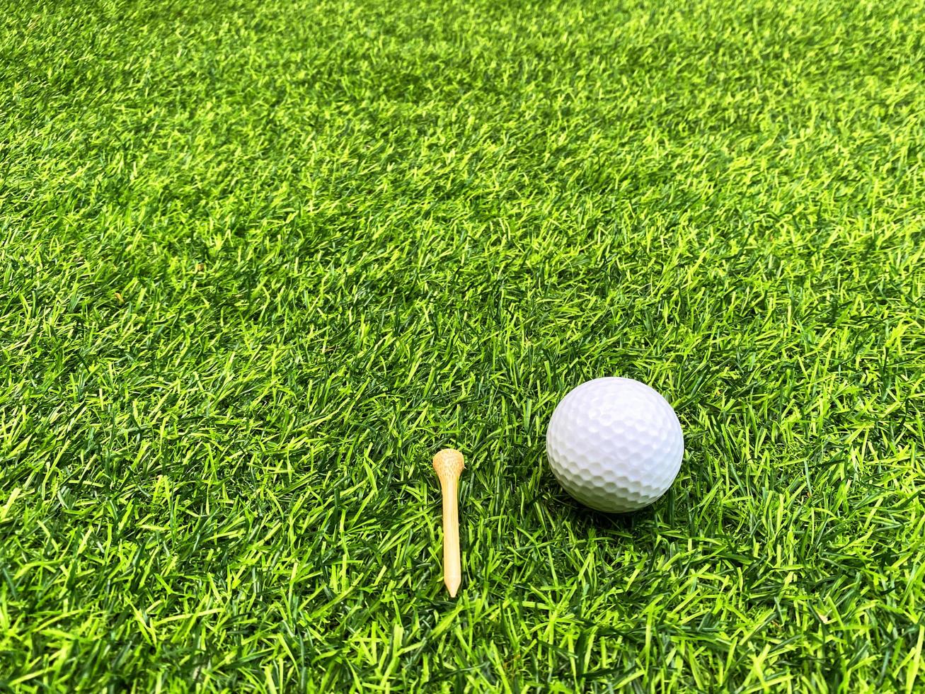 Golf ball close up on green grass on blurred beautiful landscape of golf background.Concept international sport that rely on precision skills for health relaxation. photo
