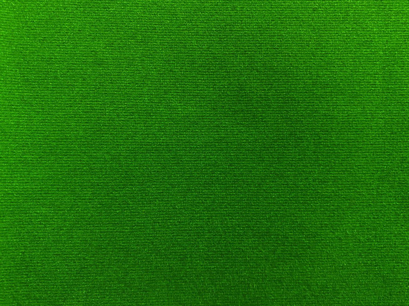 textura de tela de terciopelo verde oscuro utilizada como fondo. fondo de tela verde vacío de material textil suave y liso. hay espacio para el texto. foto