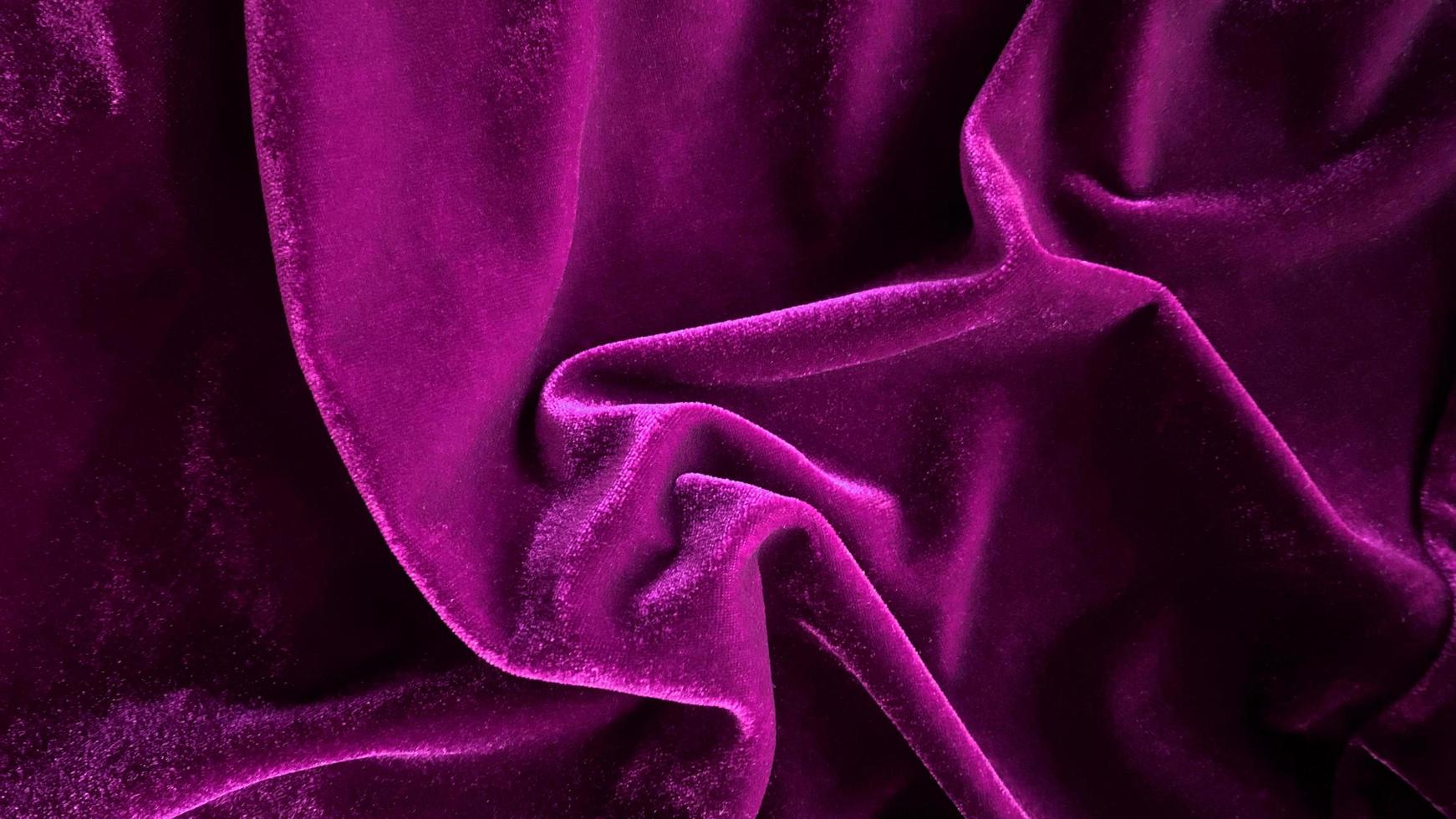 textura de tela de terciopelo magenta púrpura utilizada como fondo. fondo de tela púrpura vacío de material textil suave y liso. hay espacio para el texto. foto