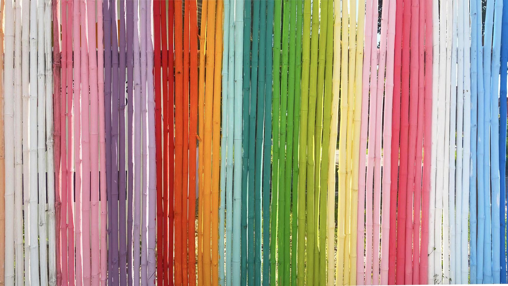 Rainbow Bamboo Wall In the bright concept of a long segmented bamboo wall painted in multi-colored Use it as a background or backdrop. photo