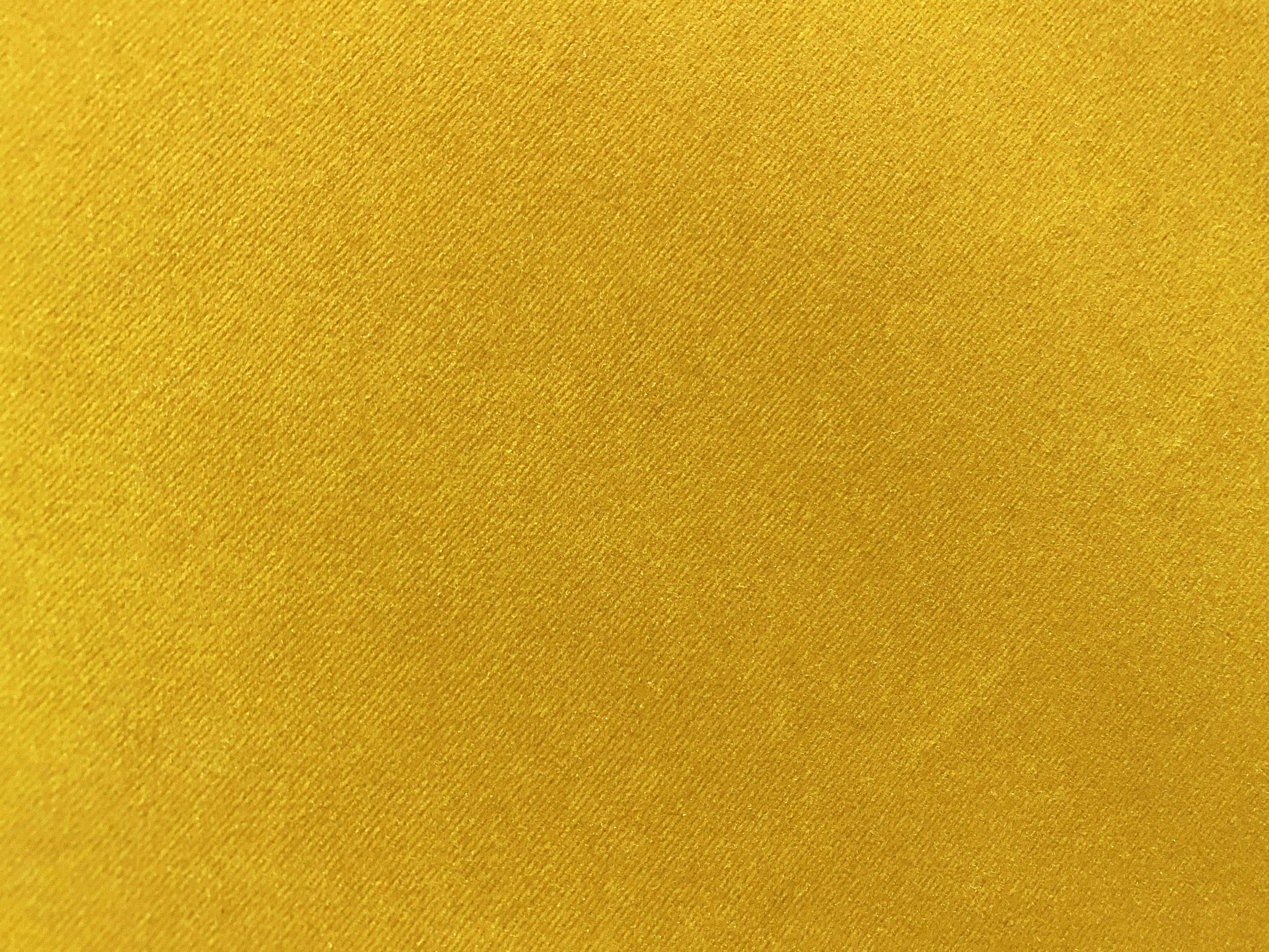 Yellow velvet fabric texture used as background. Empty yellow fabric