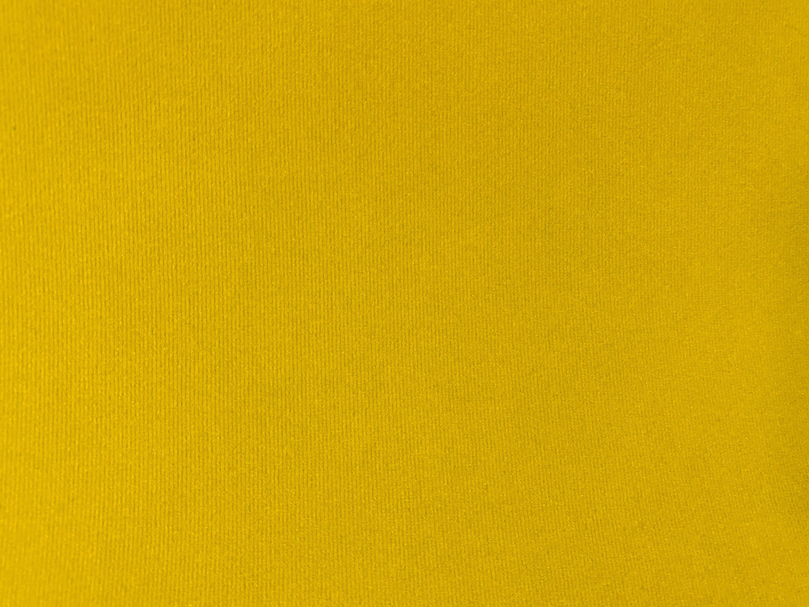 Yellow velvet fabric texture used as background. Empty yellow fabric