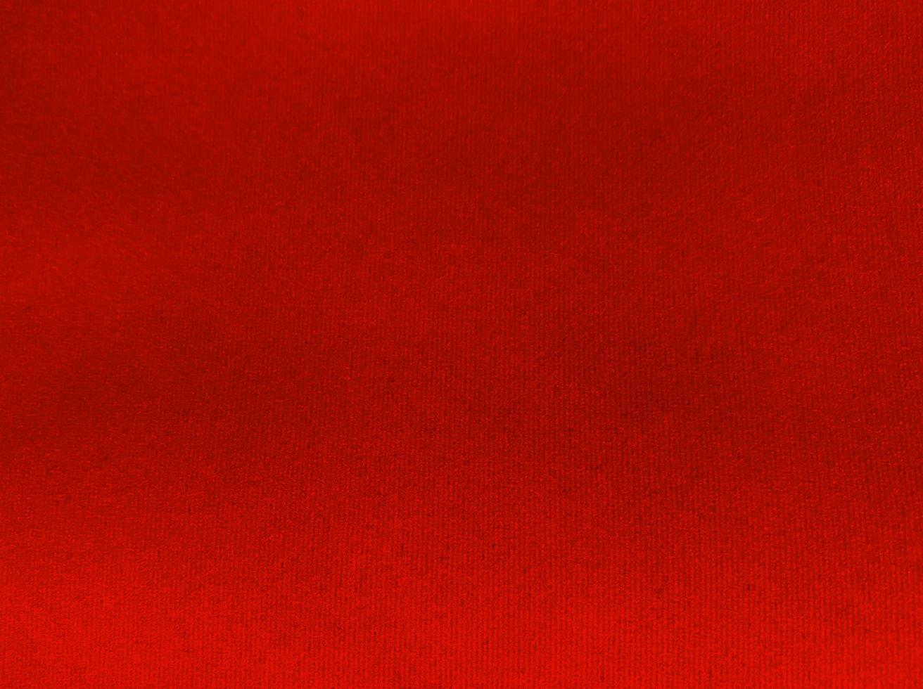 textura de tela de terciopelo rojo utilizada como fondo. fondo de tela roja vacía de material textil suave y liso. hay espacio para el texto. foto