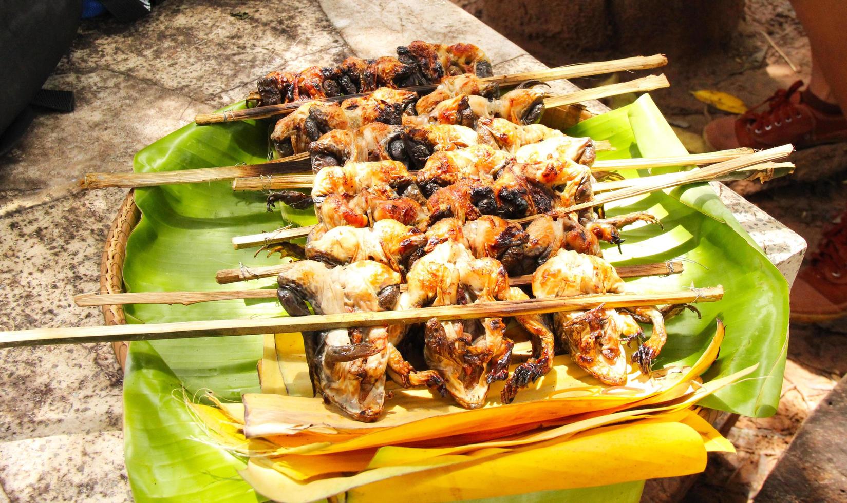 comida salvaje de rana a la parrilla, comida local, comida asiática de la calle. Las ranas rociadas con geles usan comida tailandesa ligera y fragante. foto