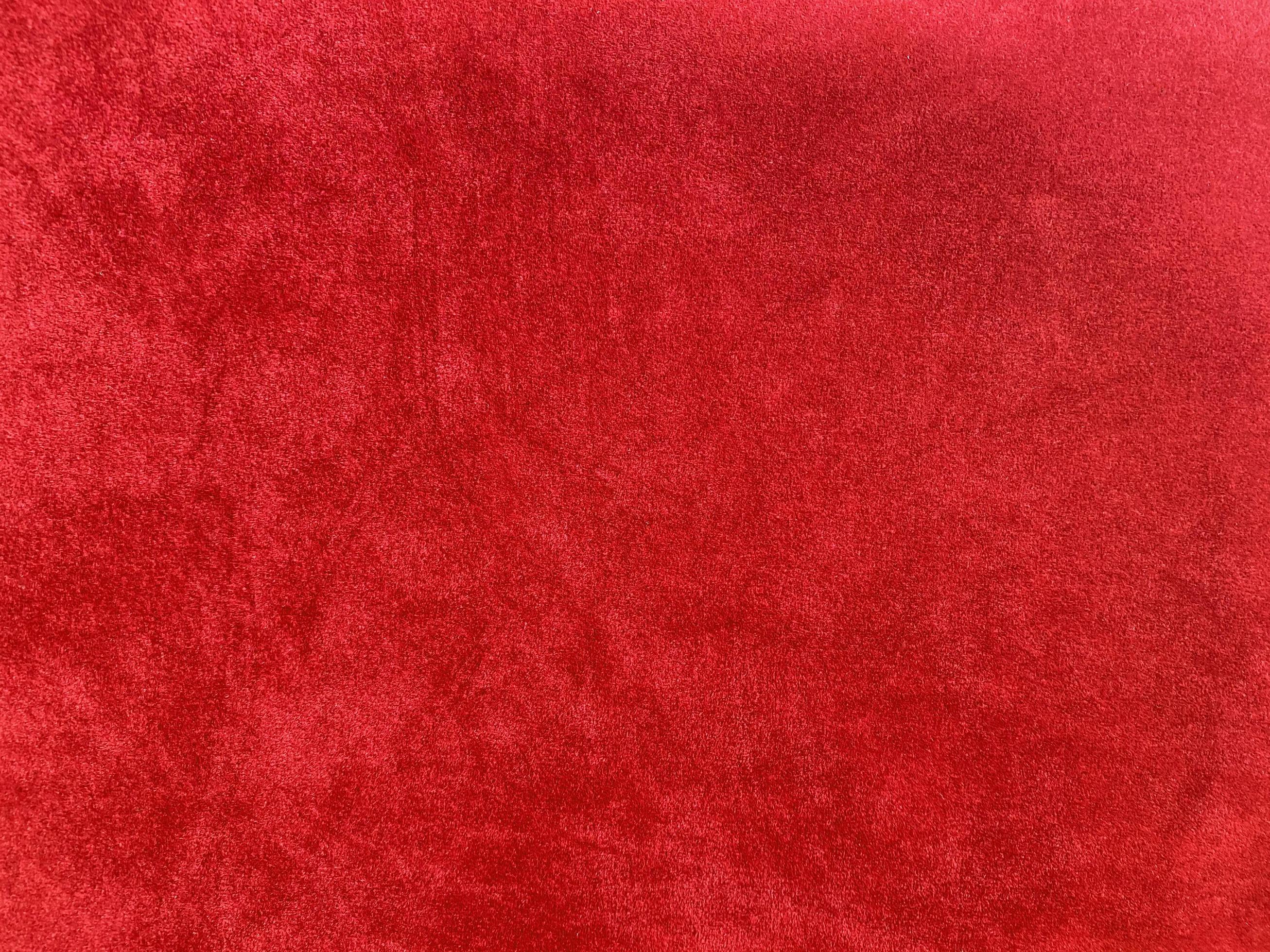Dark red velvet fabric texture used as background. Empty dark red