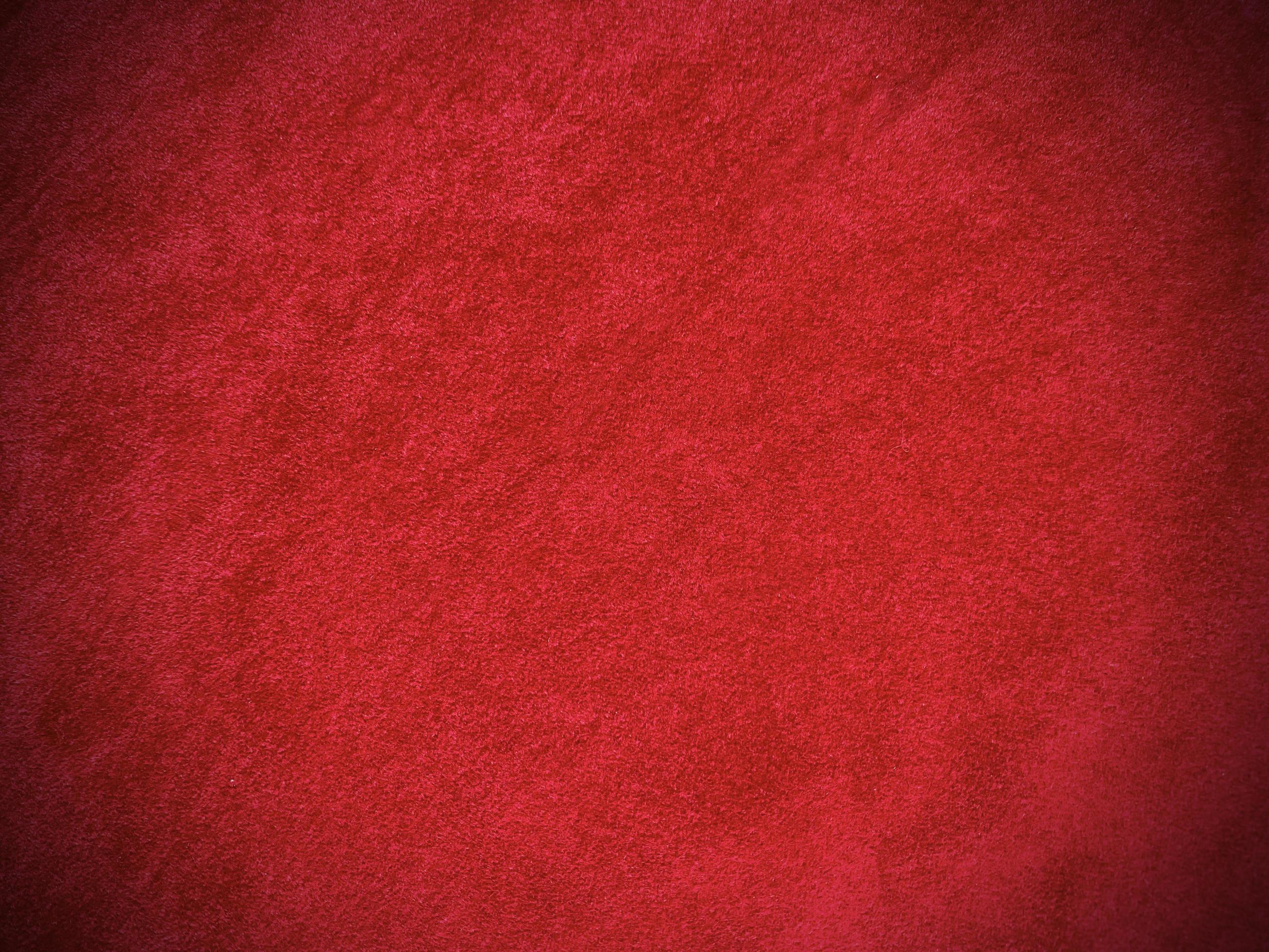 Dark red velvet fabric texture used as background. Empty dark red