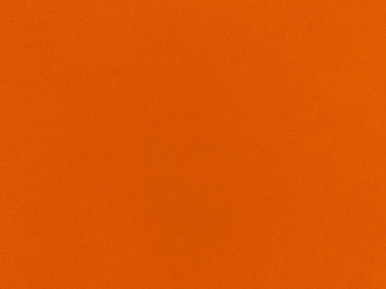 textura de tela de terciopelo naranja utilizada como fondo. fondo de tela naranja vacío de material textil suave y liso. hay espacio para el texto. foto