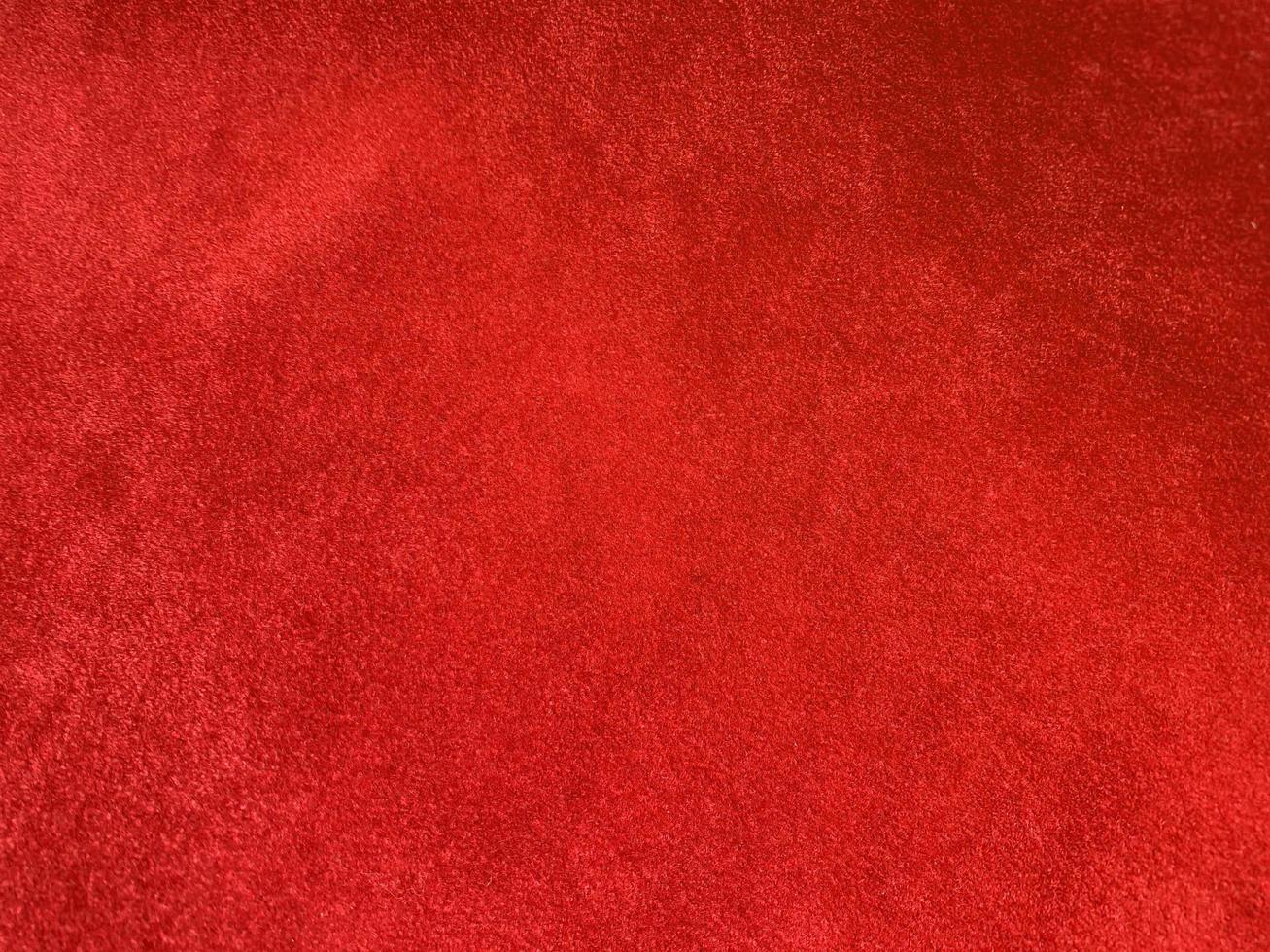 textura de tela de terciopelo rojo oscuro utilizada como fondo. fondo de tela rojo oscuro vacío de material textil suave y liso. hay espacio para el texto.. foto