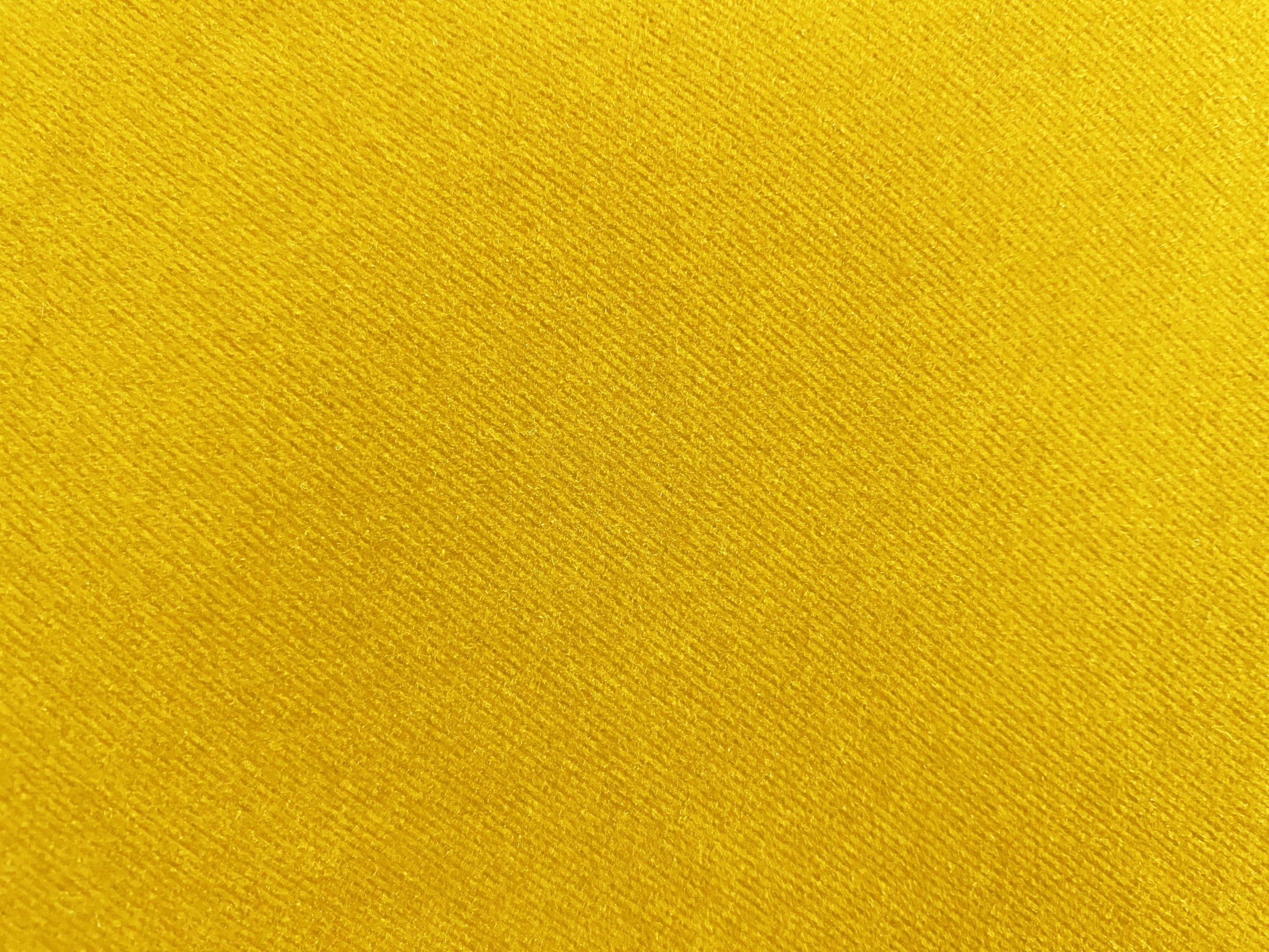 Yellow velvet fabric texture used as background. Empty yellow fabric
