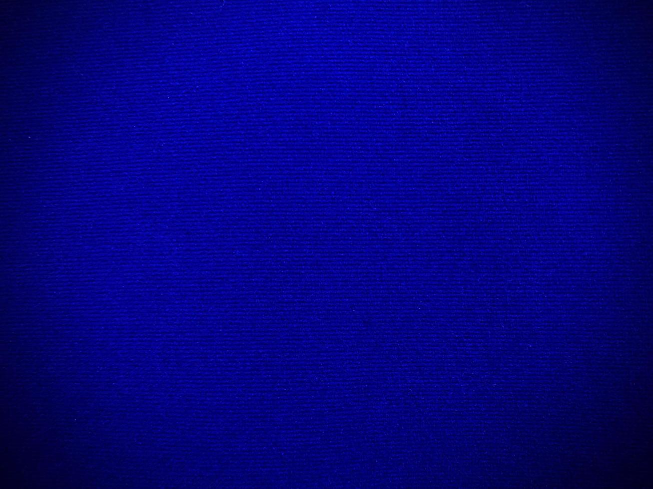 textura de tela de terciopelo azul oscuro utilizada como fondo. fondo de tela azul oscuro vacío de material textil suave y liso. hay espacio para el texto. foto