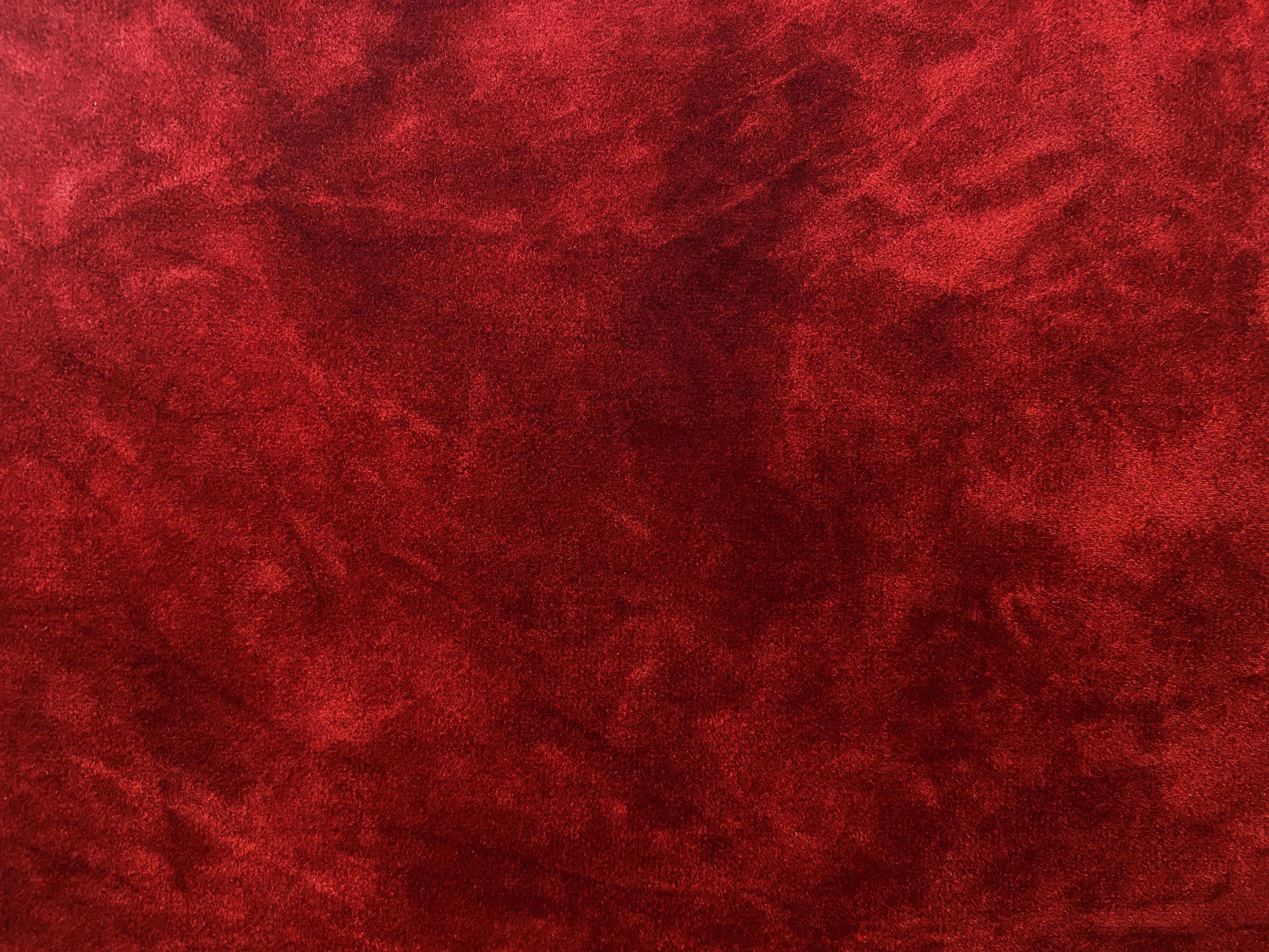 Dark red velvet fabric texture used as background. Empty dark red