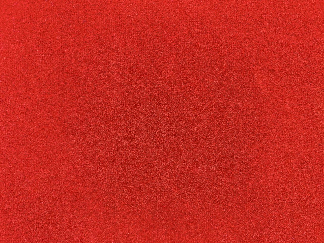 textura de tela de terciopelo rojo utilizada como fondo. fondo de tela roja vacía de material textil suave y liso. hay espacio para el texto. foto