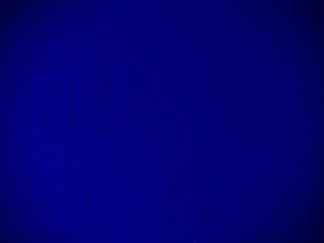 textura de tela de terciopelo azul oscuro utilizada como fondo. fondo de tela azul oscuro vacío de material textil suave y liso. hay espacio para el texto. foto