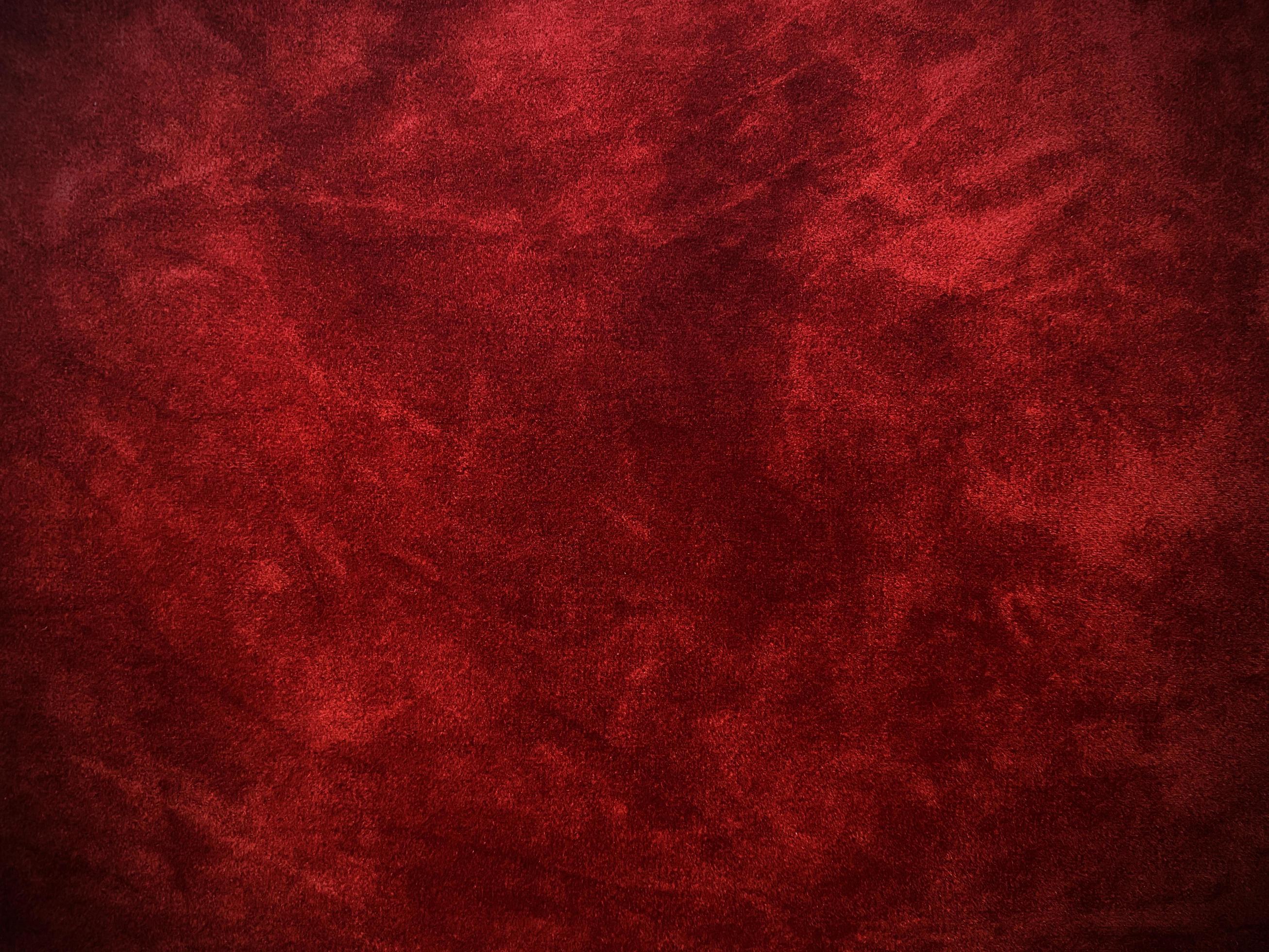 Dark red velvet fabric texture used as background. Empty dark red