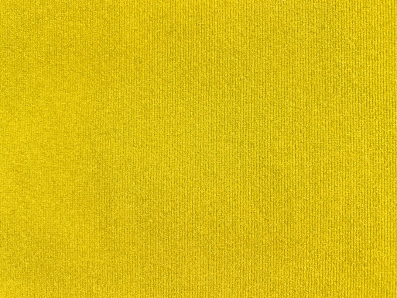 textura de tela de terciopelo amarillo utilizada como fondo. fondo de tela amarilla vacía de material textil suave y liso. hay espacio para el texto. foto