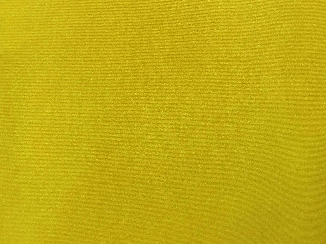 textura de tela de terciopelo amarillo utilizada como fondo. fondo de tela amarilla vacía de material textil suave y liso. hay espacio para el texto... foto