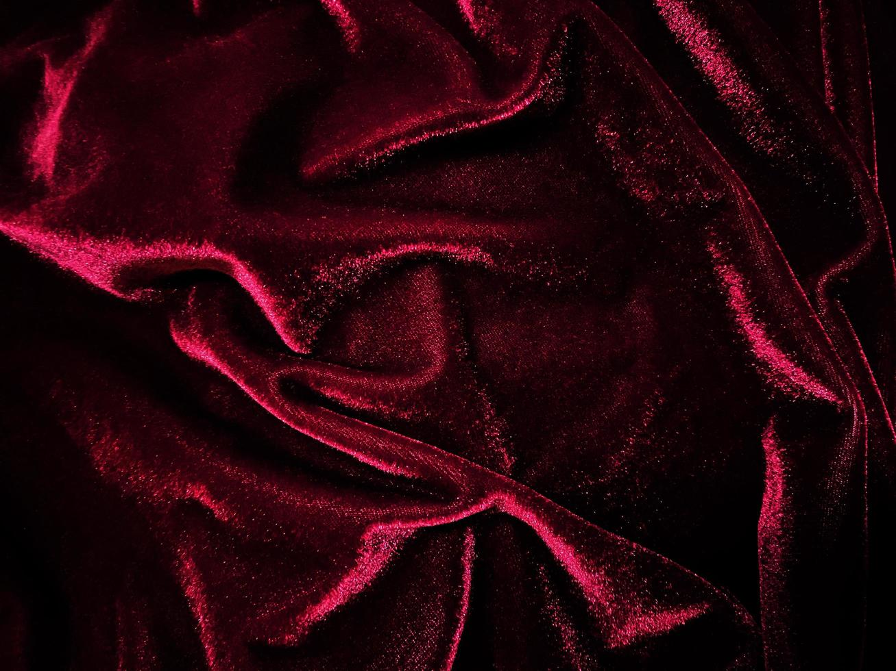 textura de tela de terciopelo rojo utilizada como fondo. fondo de tela roja vacía de material textil suave y liso. hay espacio para el texto. foto