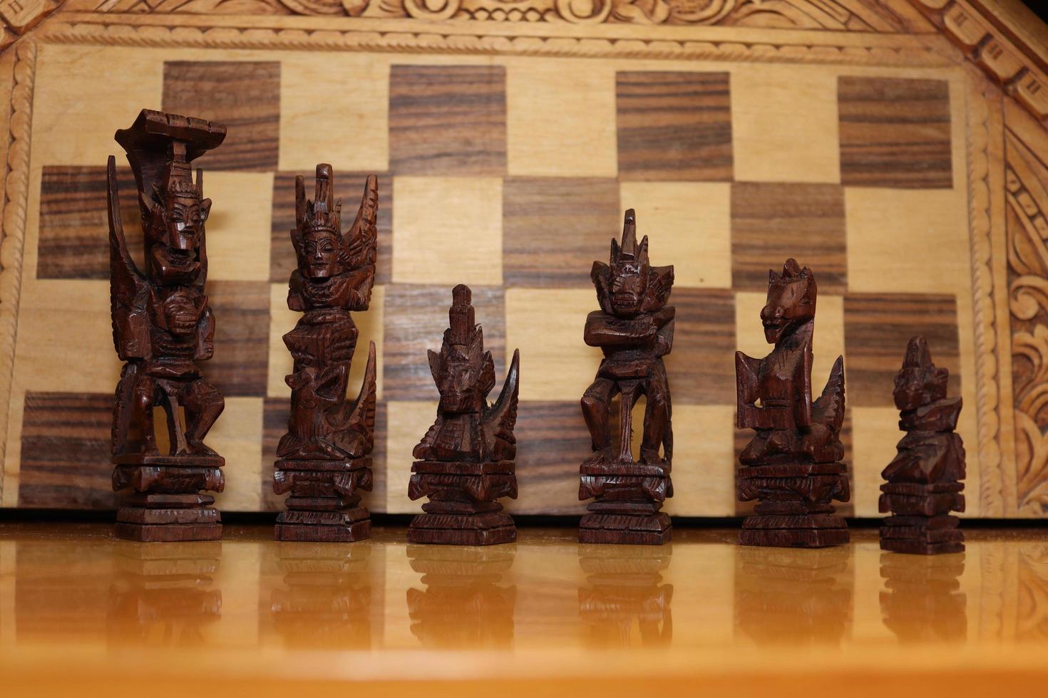 Mayan chess pieces photographed on a background showing a chess board photo