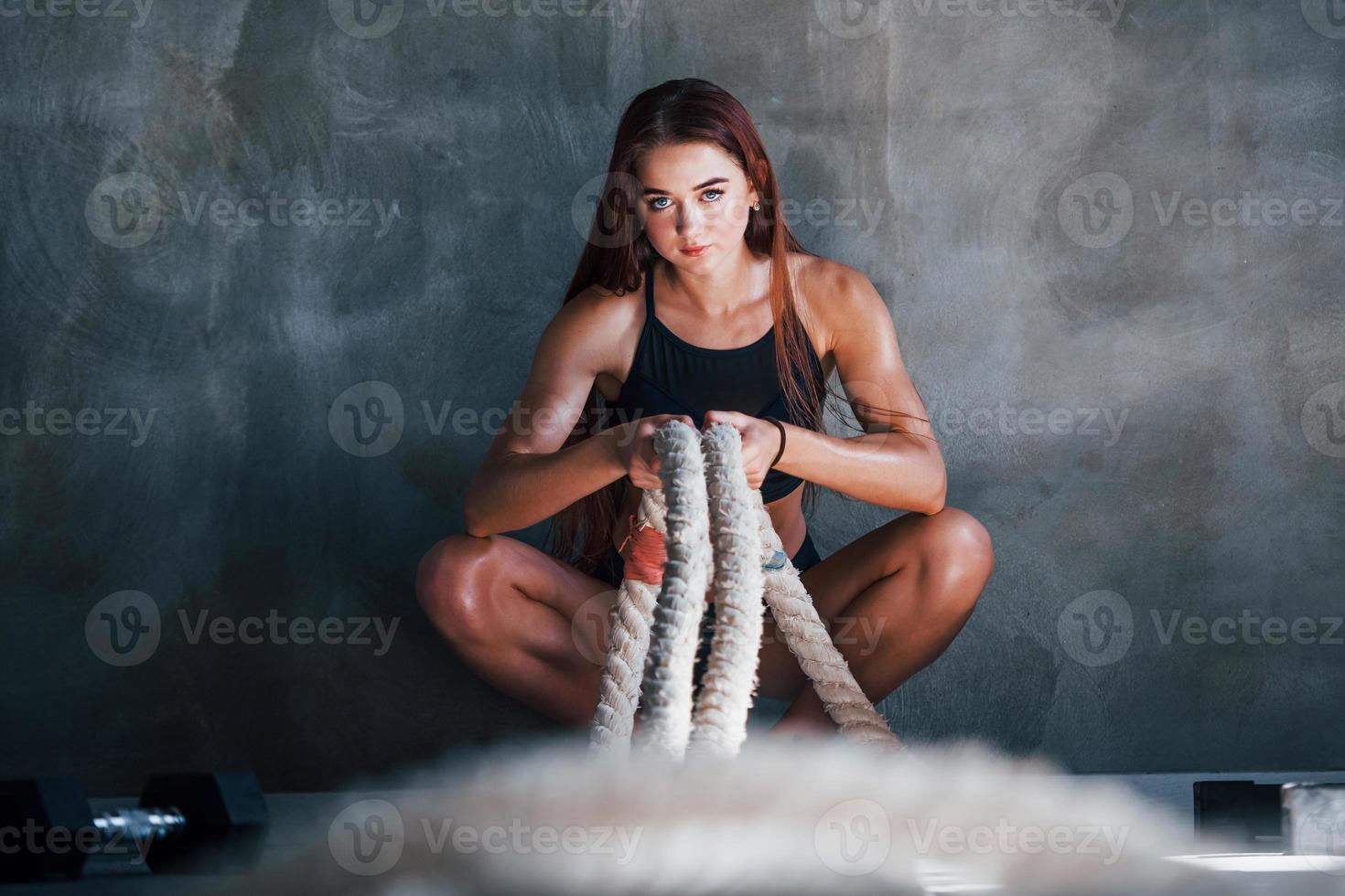 Young fitness woman with slim type of body sits with knots in hands photo