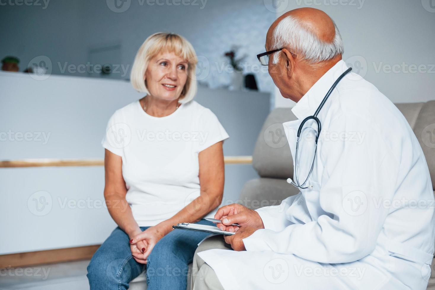 mujer mayor tiene consulta en la clínica por el médico masculino foto
