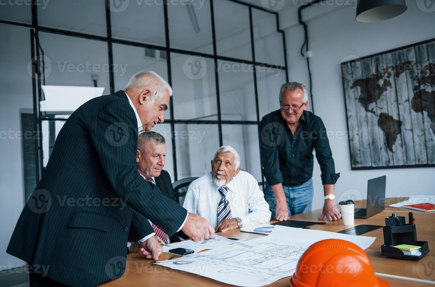 un equipo de ancianos arquitectos de hombres de negocios tiene una reunión en la oficina foto