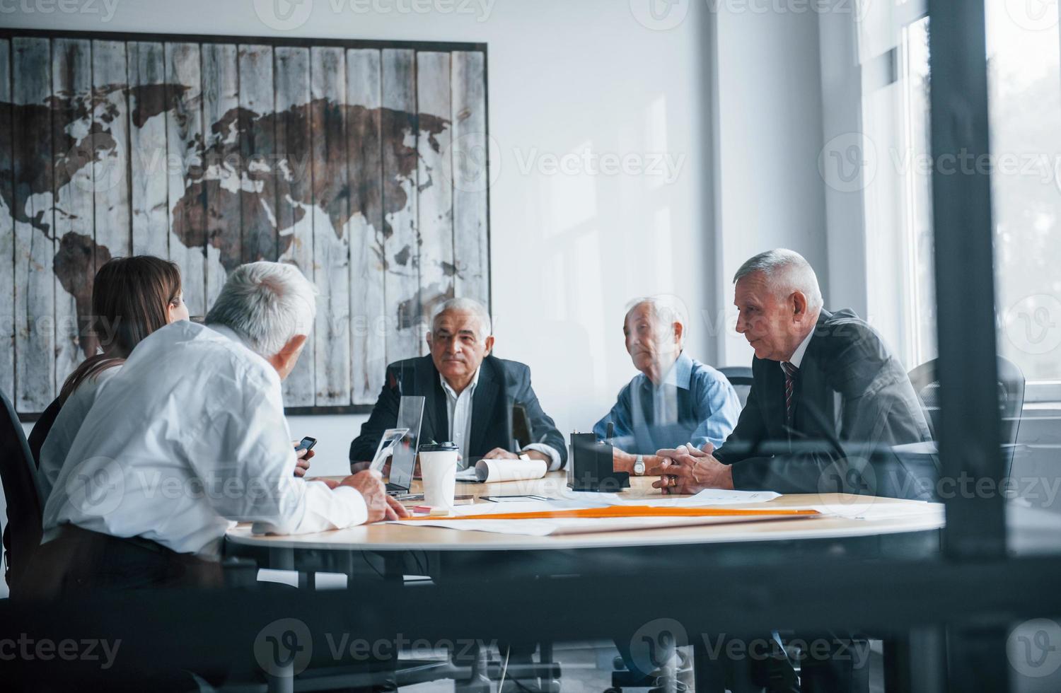 un equipo anciano de arquitectos de negocios de edad avanzada tiene una reunión en la oficina y trabaja con una mujer joven foto