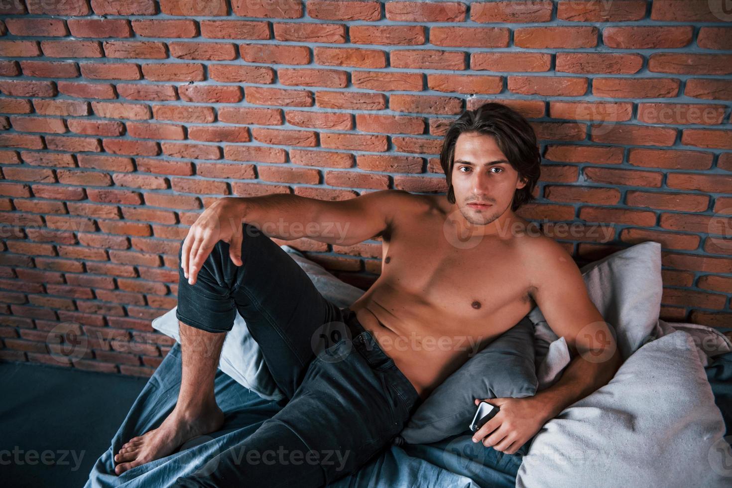 Shirtless sexy man have a rest alone in his bedroom at morning time photo