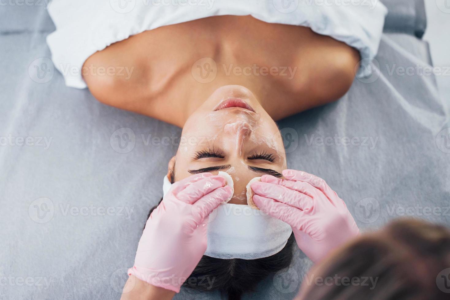 Close up view of woman that lying down in spa salon and have face cleaning procedure photo