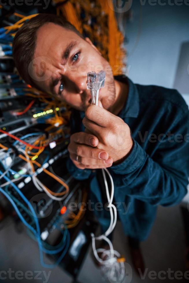 Close up view of funny man with internet wires in server room photo