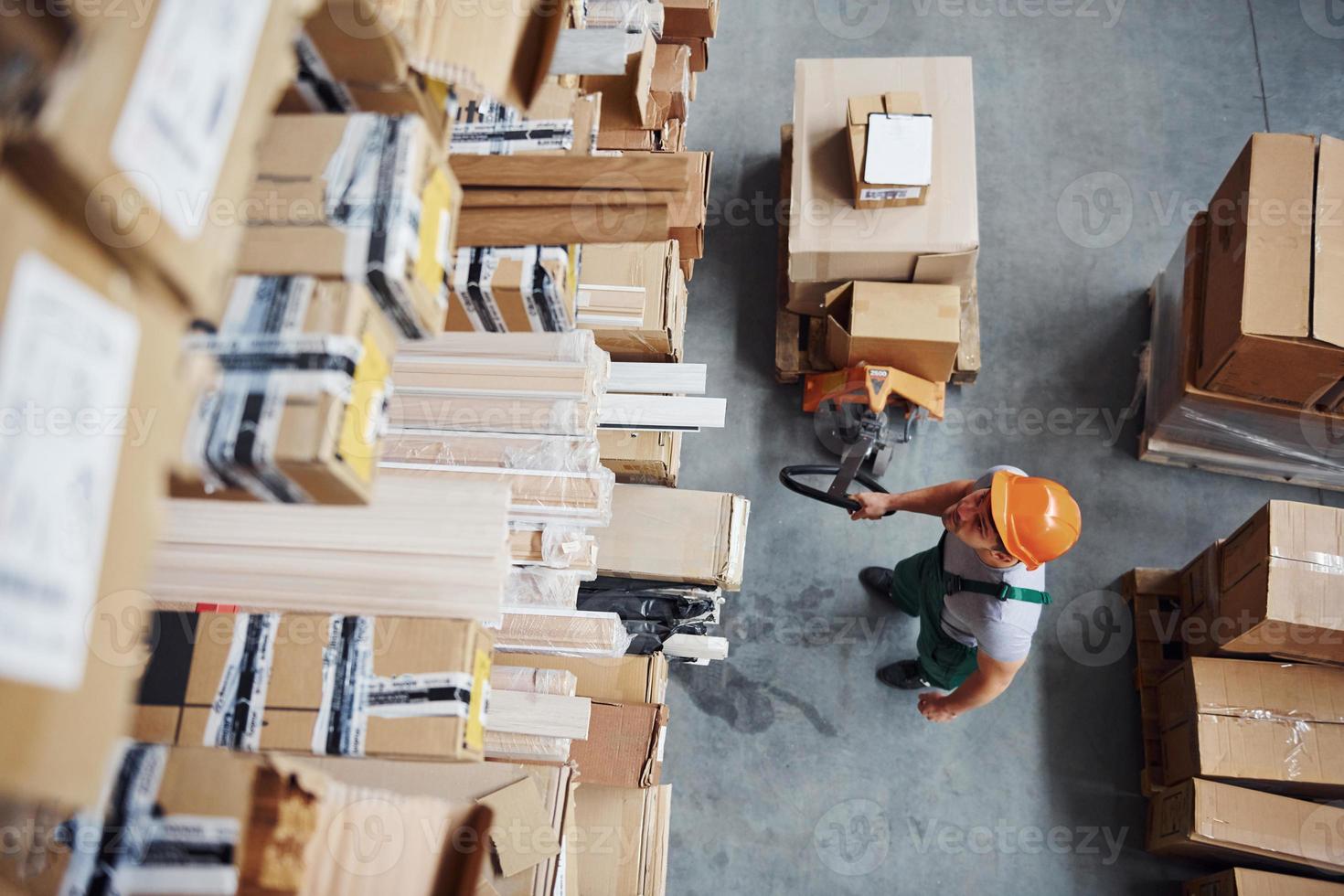 vista superior del trabajador masculino en almacén con transpaleta foto