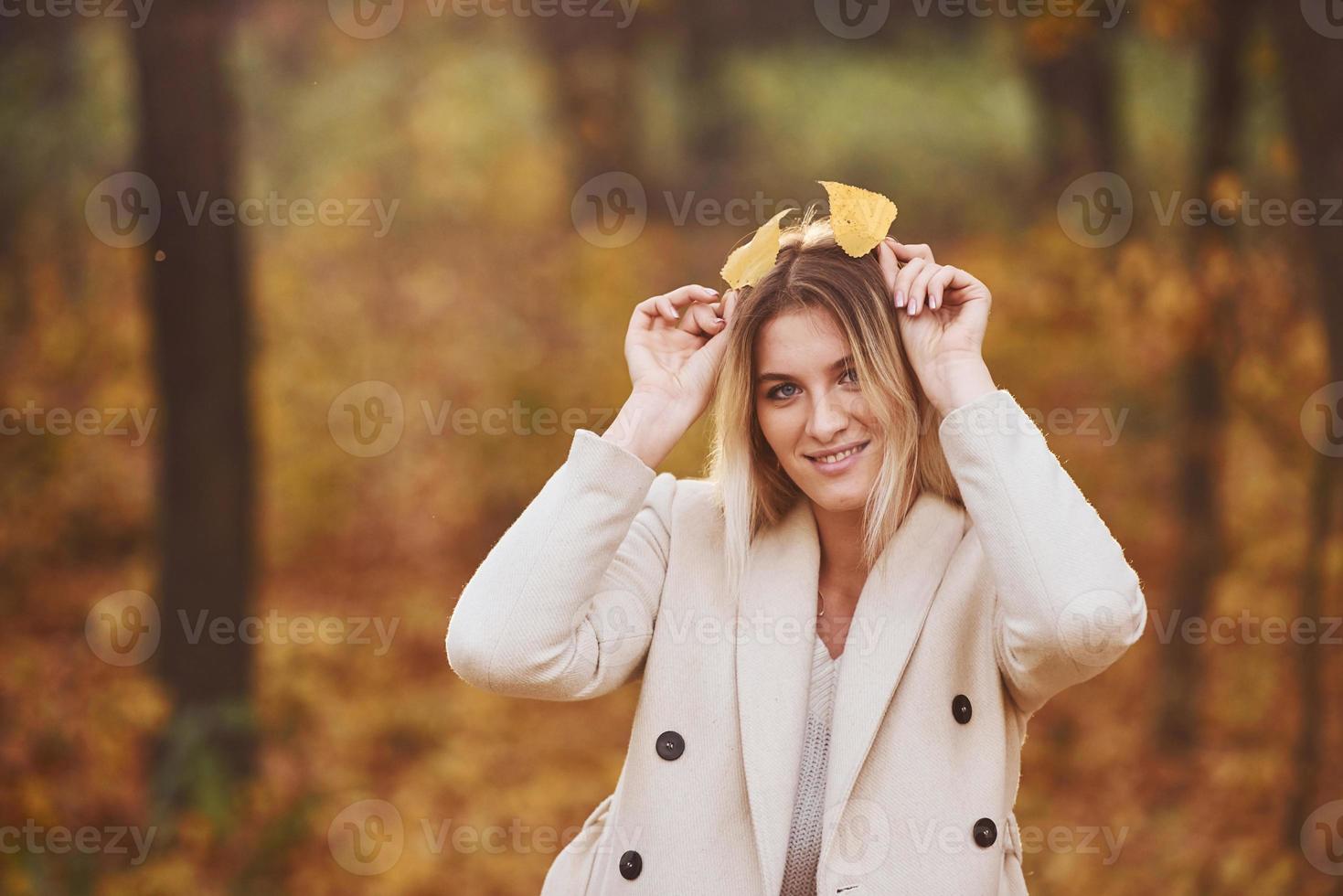 Portrait of young brunette that have fun in autumn forest at daytime photo