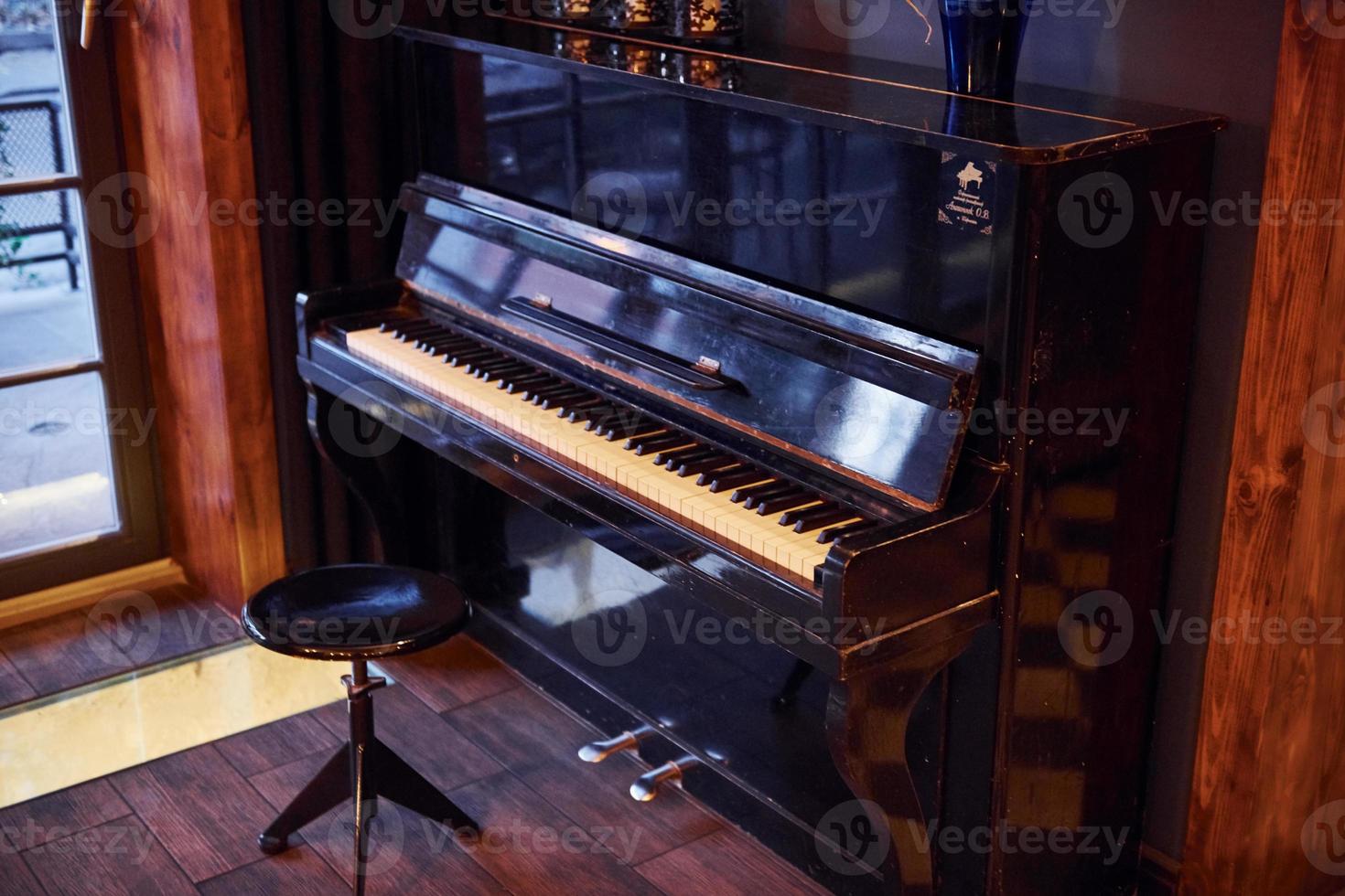 Piano and chair indoors in modern restaurant with no people in it photo