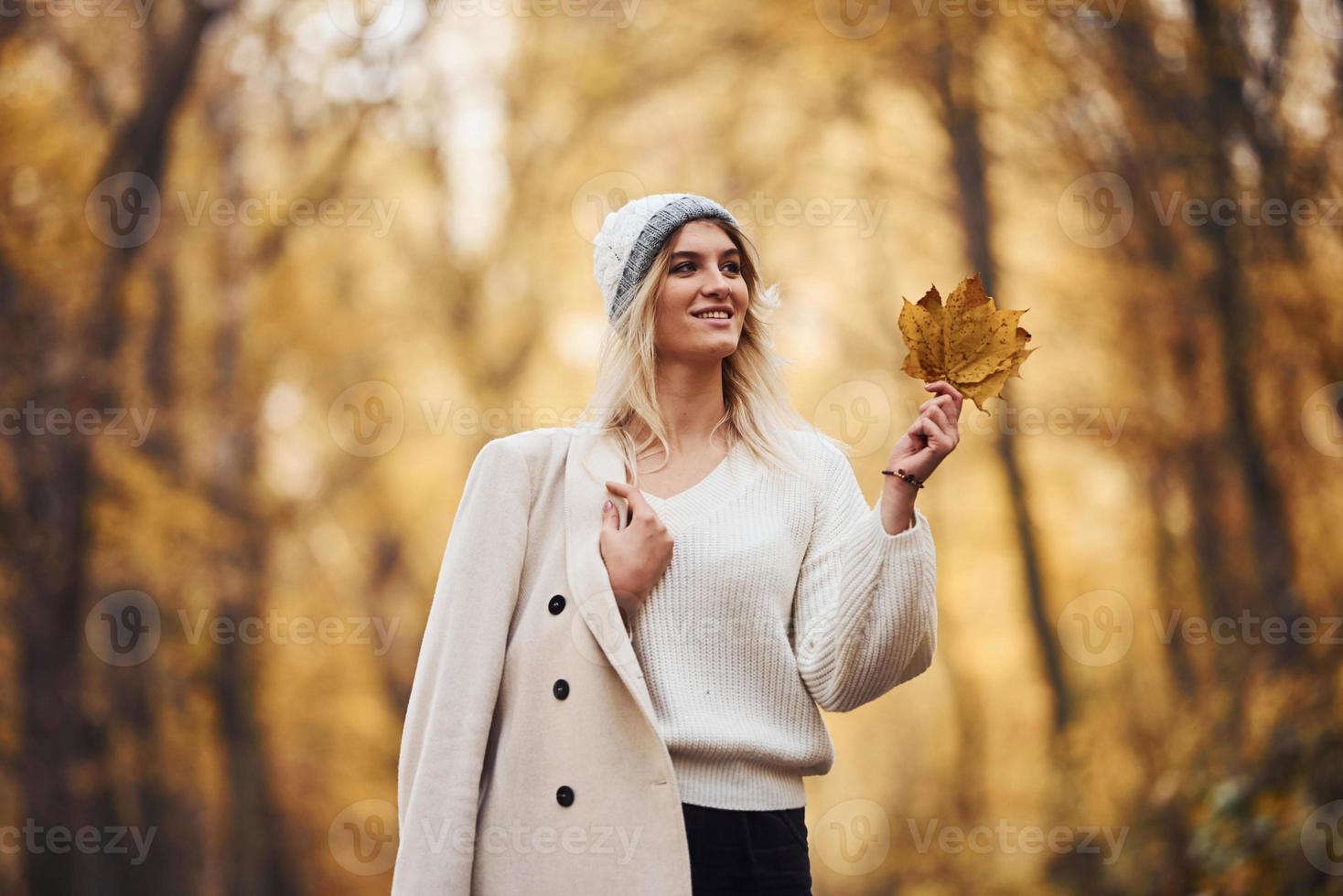 Portrait of young brunette that have a walk on road in autumn forest at daytime photo