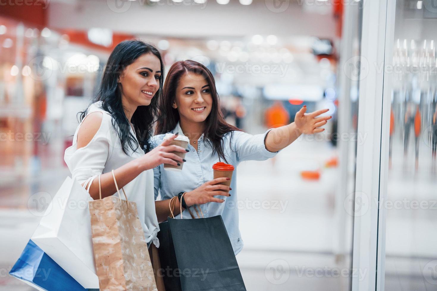 Two young women have a shopping day together in the supermarket photo