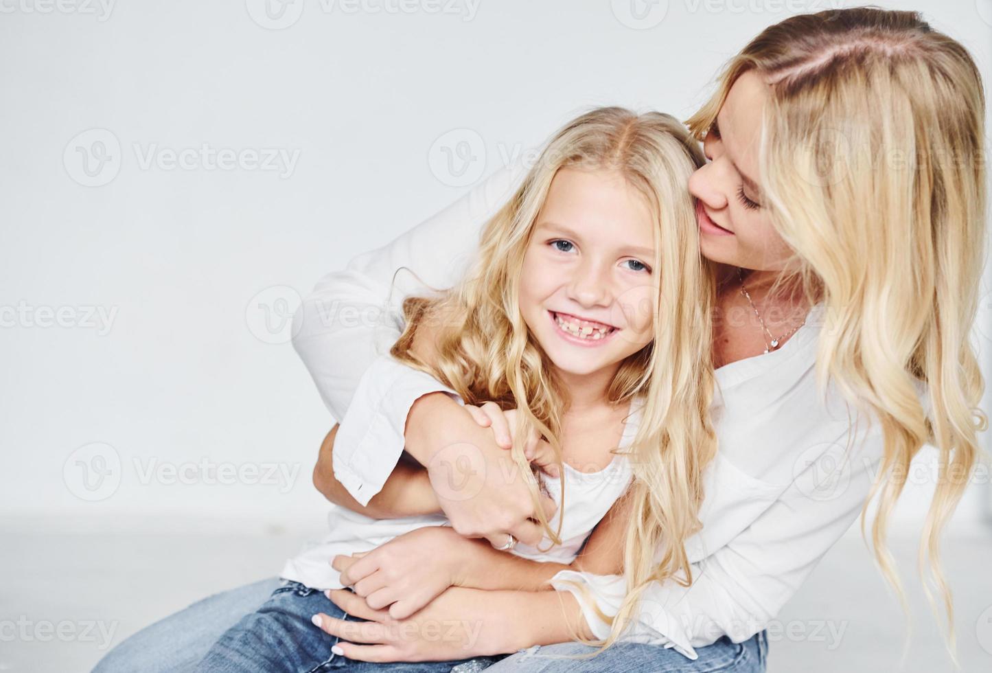 Closeness of the people. Mother with her daughter together in the studio with white background photo