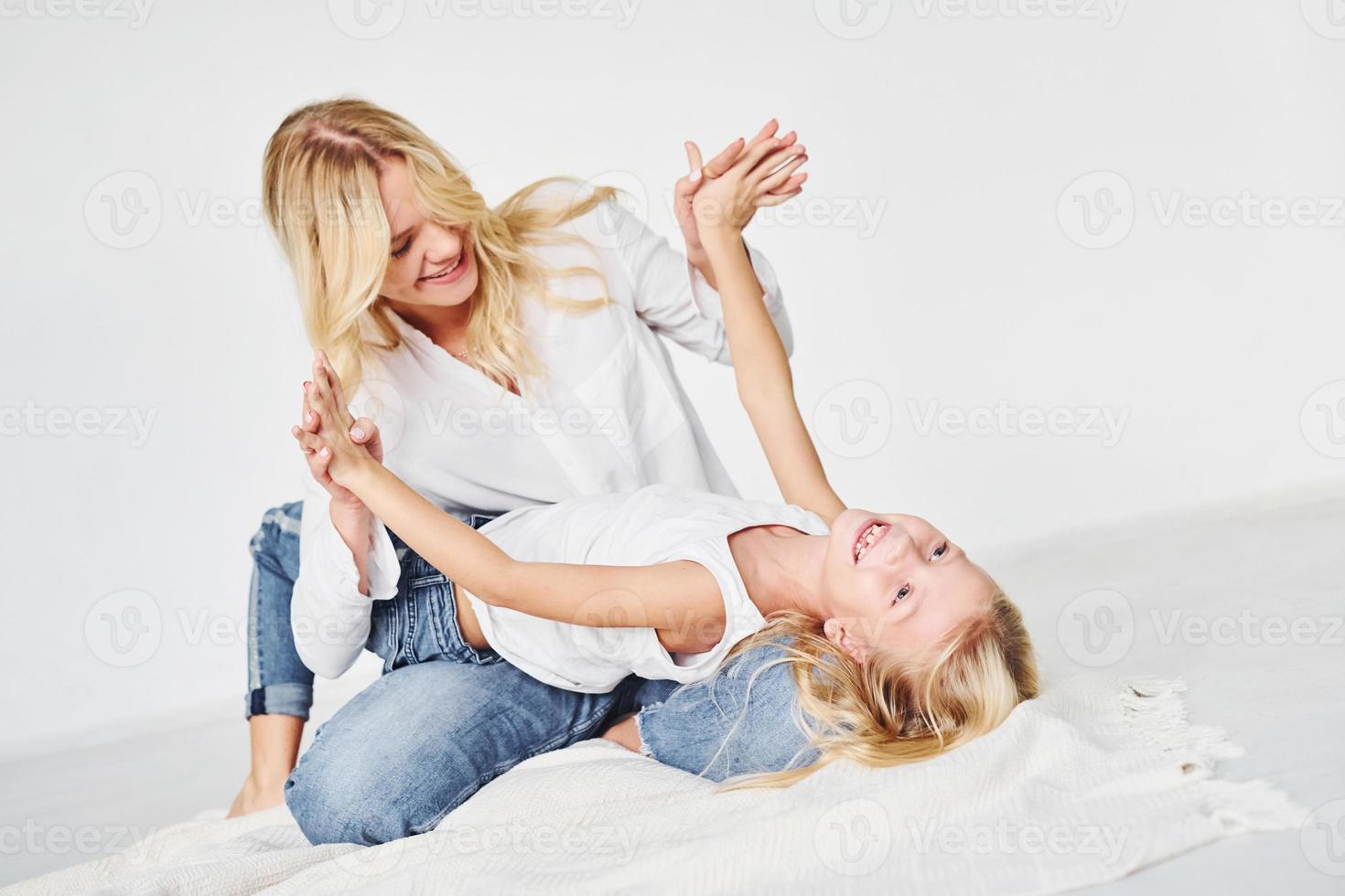 Closeness of the people. Mother with her daughter together in the studio with white background photo