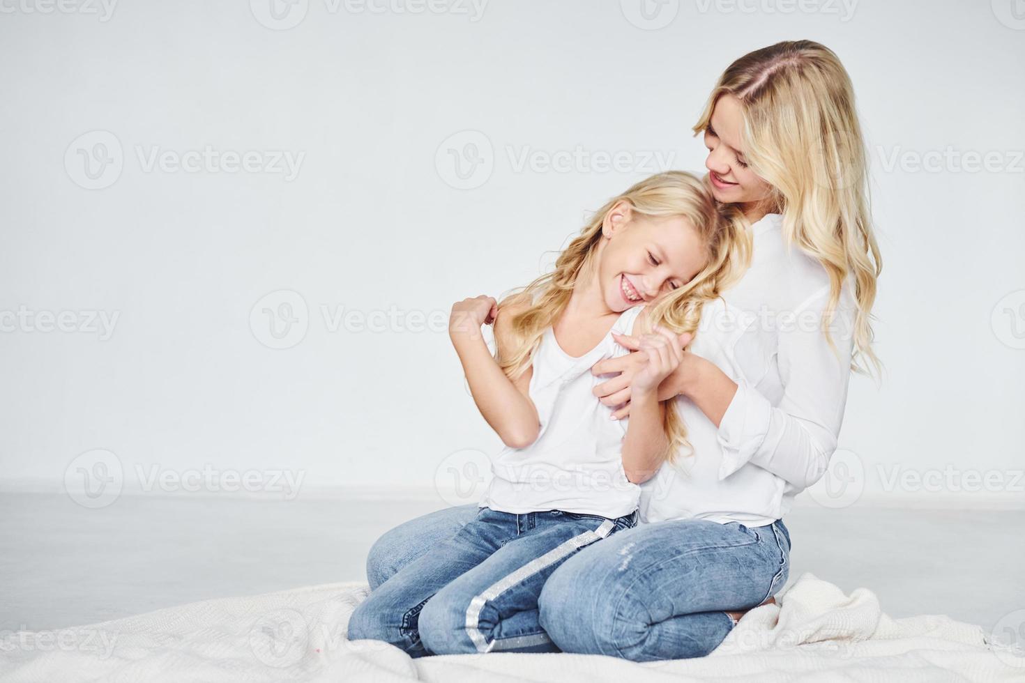 cercanía de la gente. madre con su hija juntas en el estudio con antecedentes blancos foto