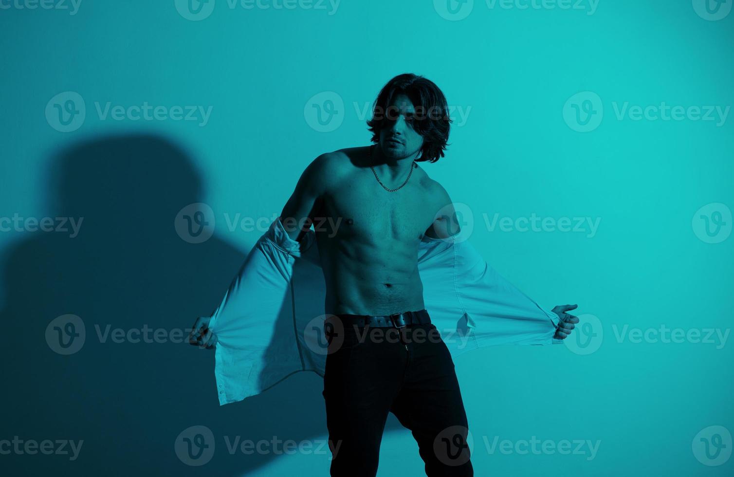Portrait of young hot man that stands in neon lights in the studio photo