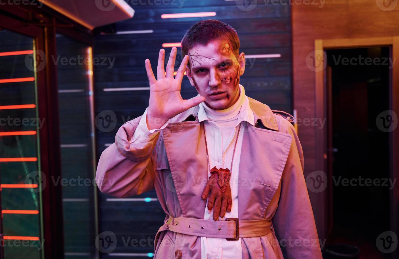 retrato de hombre que está en la fiesta temática de halloween con maquillaje y disfraz de zombi foto