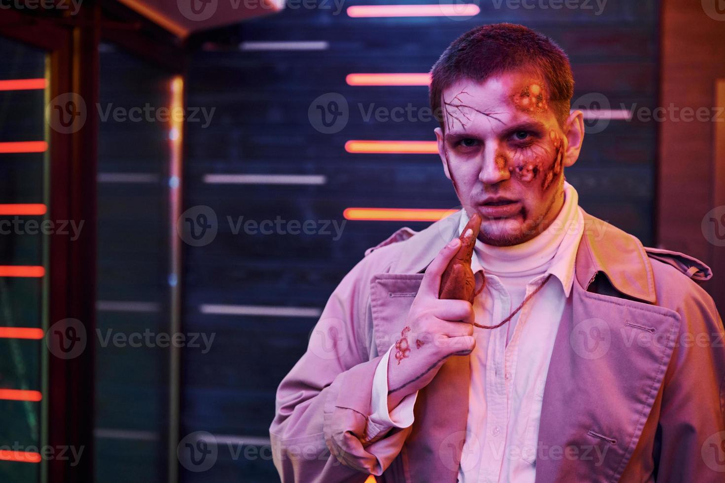 Portrait of man that is on the thematic halloween party in zombie makeup and costume photo