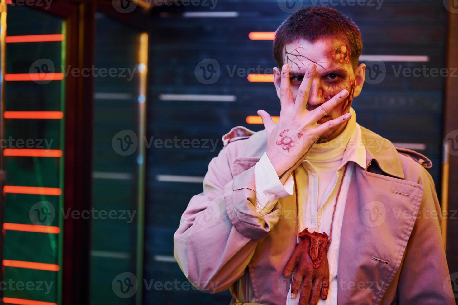 Portrait of man that is on the thematic halloween party in zombie makeup and costume photo