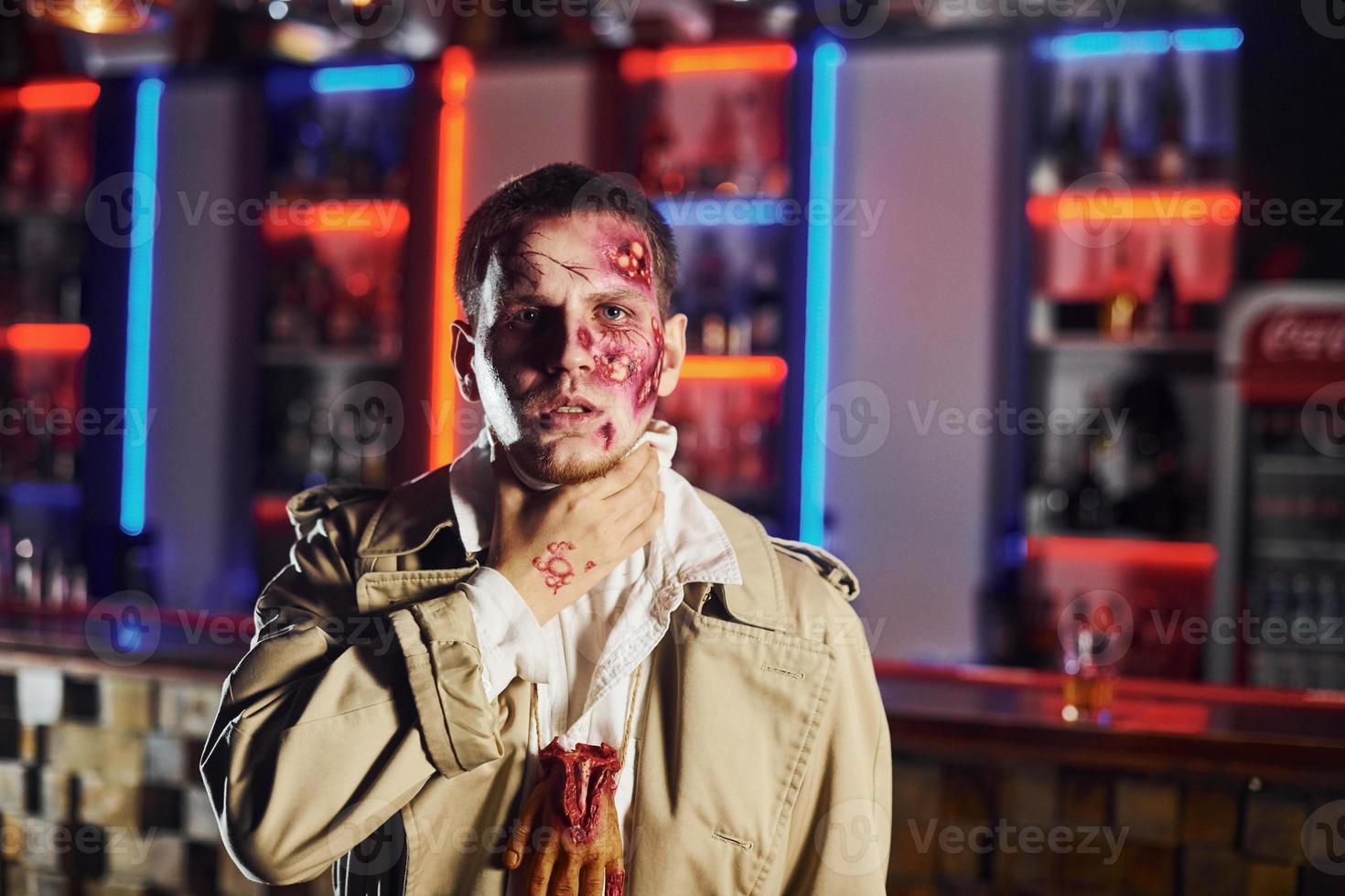 Portrait of man that is on the thematic halloween party in zombie makeup and costume photo