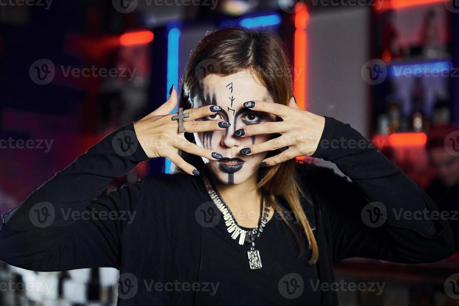 Portrait of woman that is on the thematic halloween party in scary makeup and costume photo