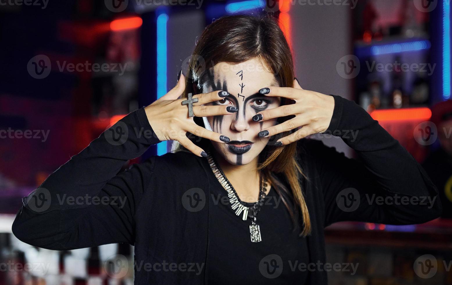 Portrait of woman that is on the thematic halloween party in scary makeup and costume photo
