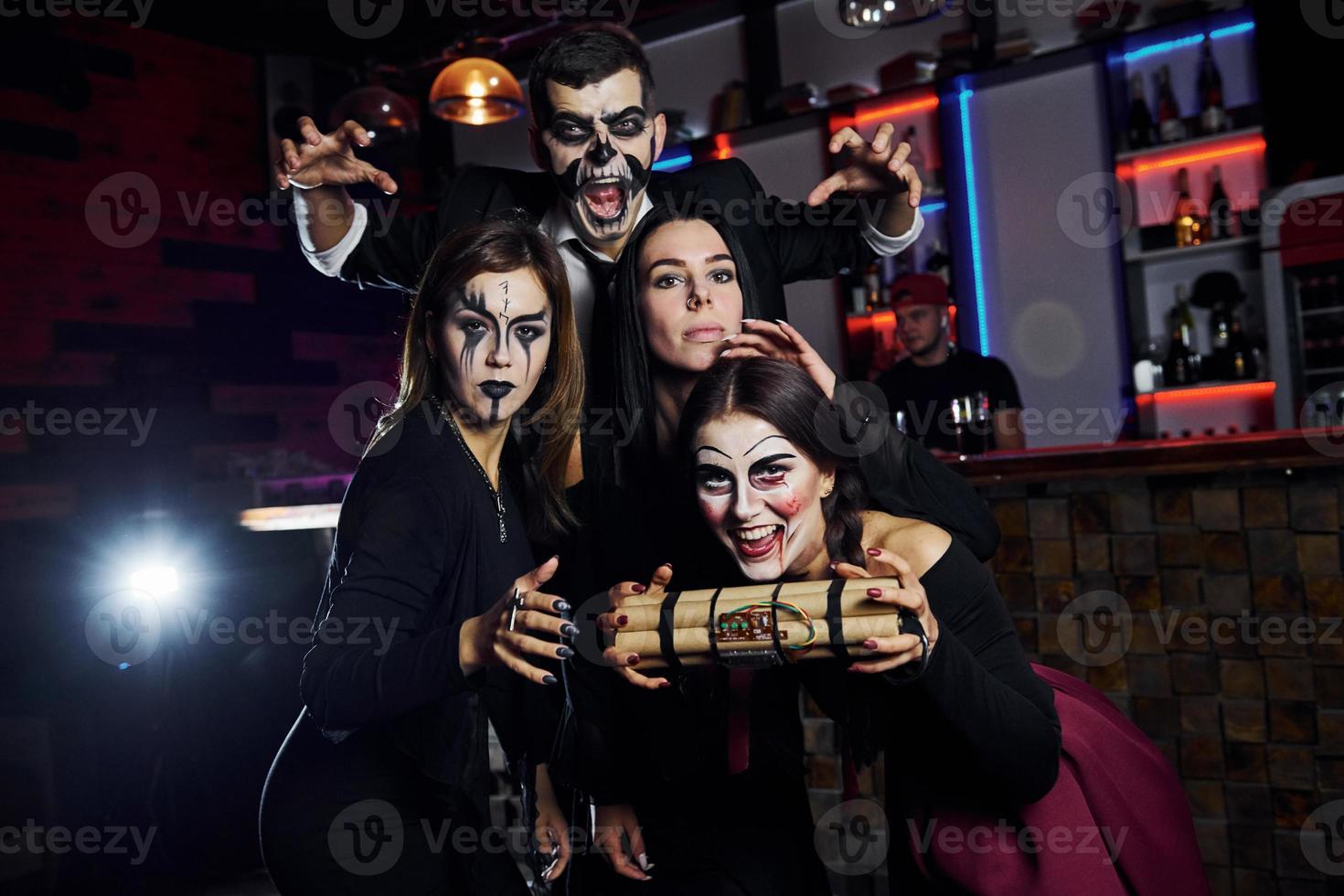 Showing bomb. Friends is on the thematic halloween party in scary makeup and costumes photo