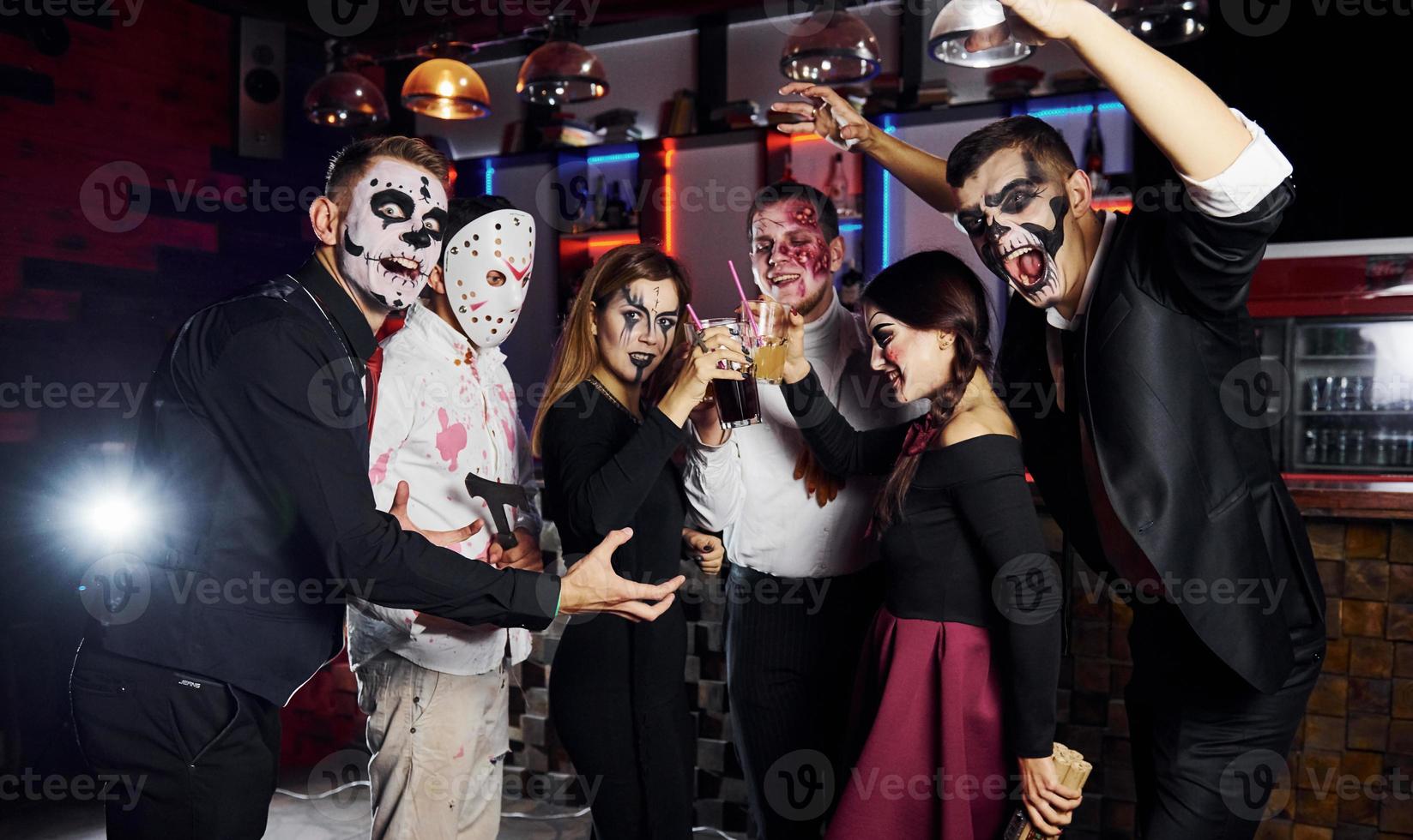 Posing for the camera. Friends is on the thematic halloween party in scary makeup and costumes photo