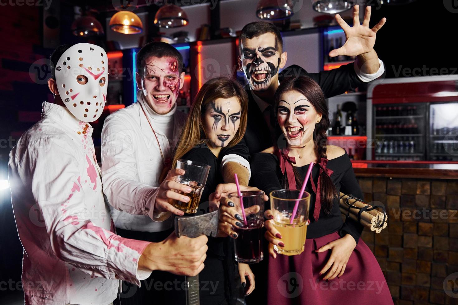 Posing for the camera. Friends is on the thematic halloween party in scary makeup and costumes photo